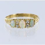 18ct yellow gold ring set with three graduated oval opal cabochons spaced by four round old cut