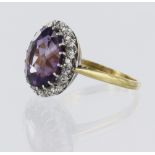 Stamped '18CT PLAT' amethyst and diamond cluster dress ring, oval amethyst measures 12mm x 10mm,