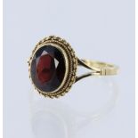 9ct yellow gold ring set with an oval garnet measuring approx. 10mm x 8mm in a rope edge setting,