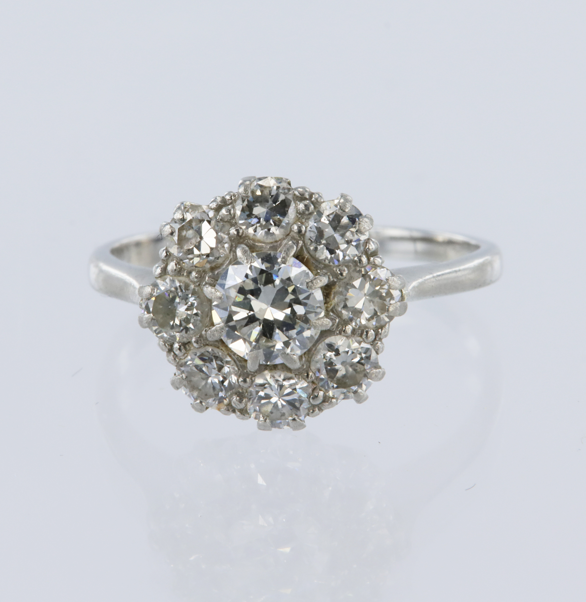 White metal stamped 'PLAT' diamond daisy cluster ring, principle round brilliant cut diamond