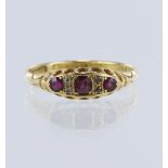 18ct yellow gold diamond and ruby boat shaped ring, three graduating round cut rubies, centre ruby