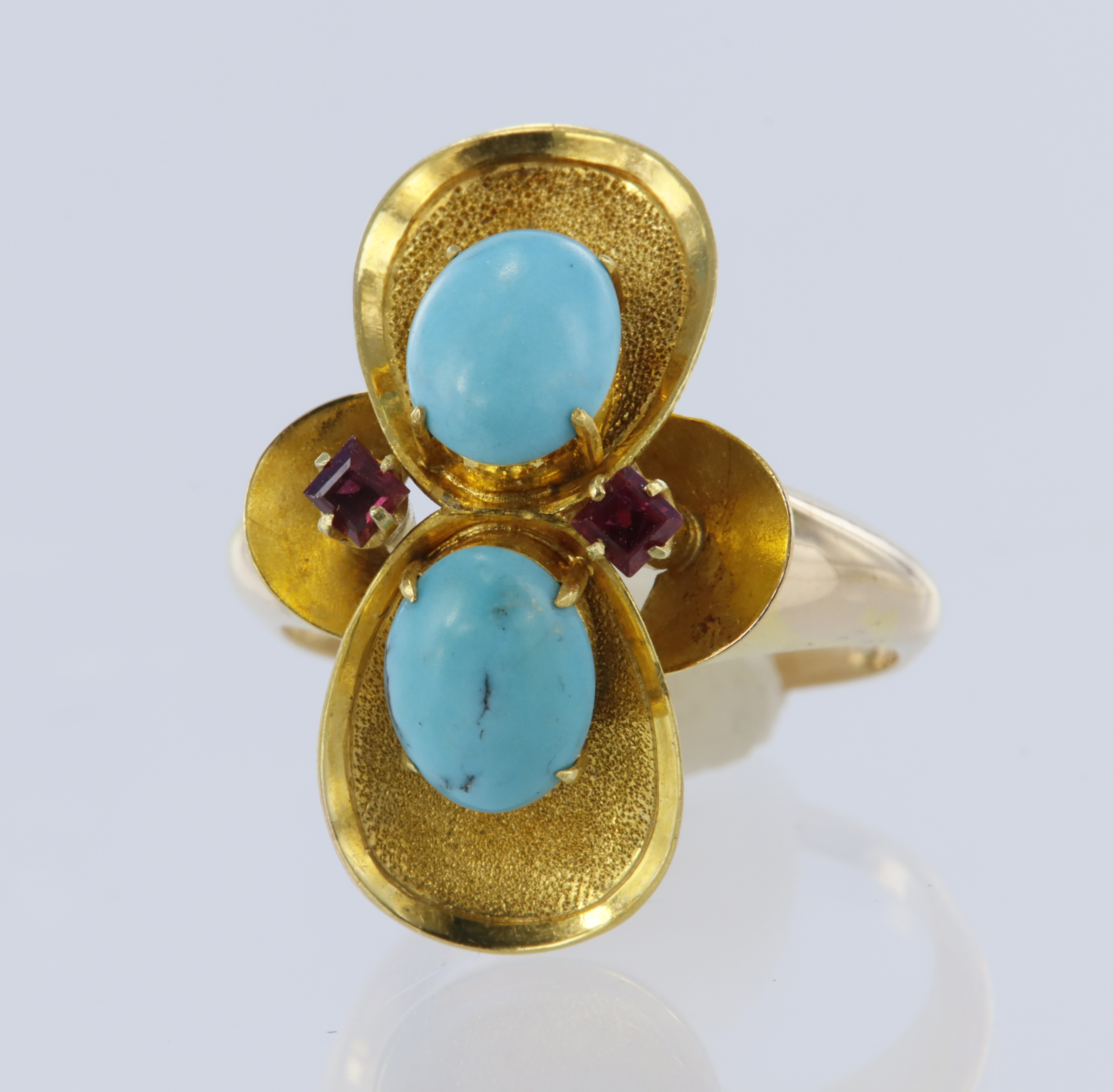 Yellow metal (tests 14ct) turquoise and ruby dress ring, two oval cabochon cut turquoise measuring
