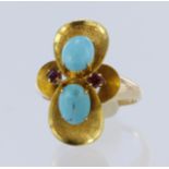 Yellow metal (tests 14ct) turquoise and ruby dress ring, two oval cabochon cut turquoise measuring