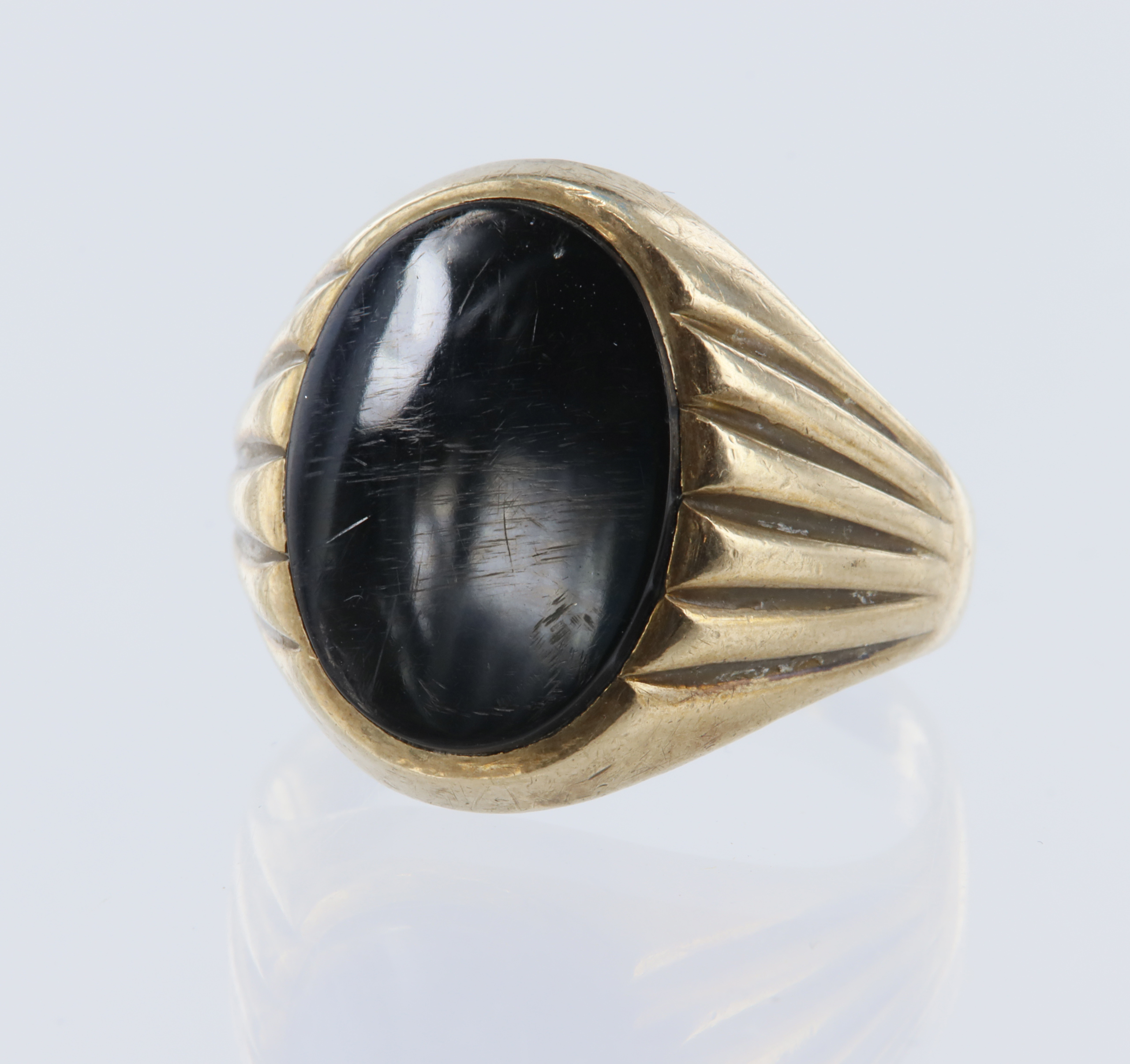 Yellow gold (tests 9ct) signet ring set with a oval shaped onyx measuring 15.8mm x 11.7mm, finger