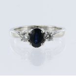Platinum trilogy ring, set with one oval mixed cut dark blue sapphire approx weight 1.05ct,