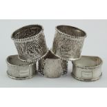 Five silver napkin rings comprising two highly decorated Indian unmarked silver rings + two matching