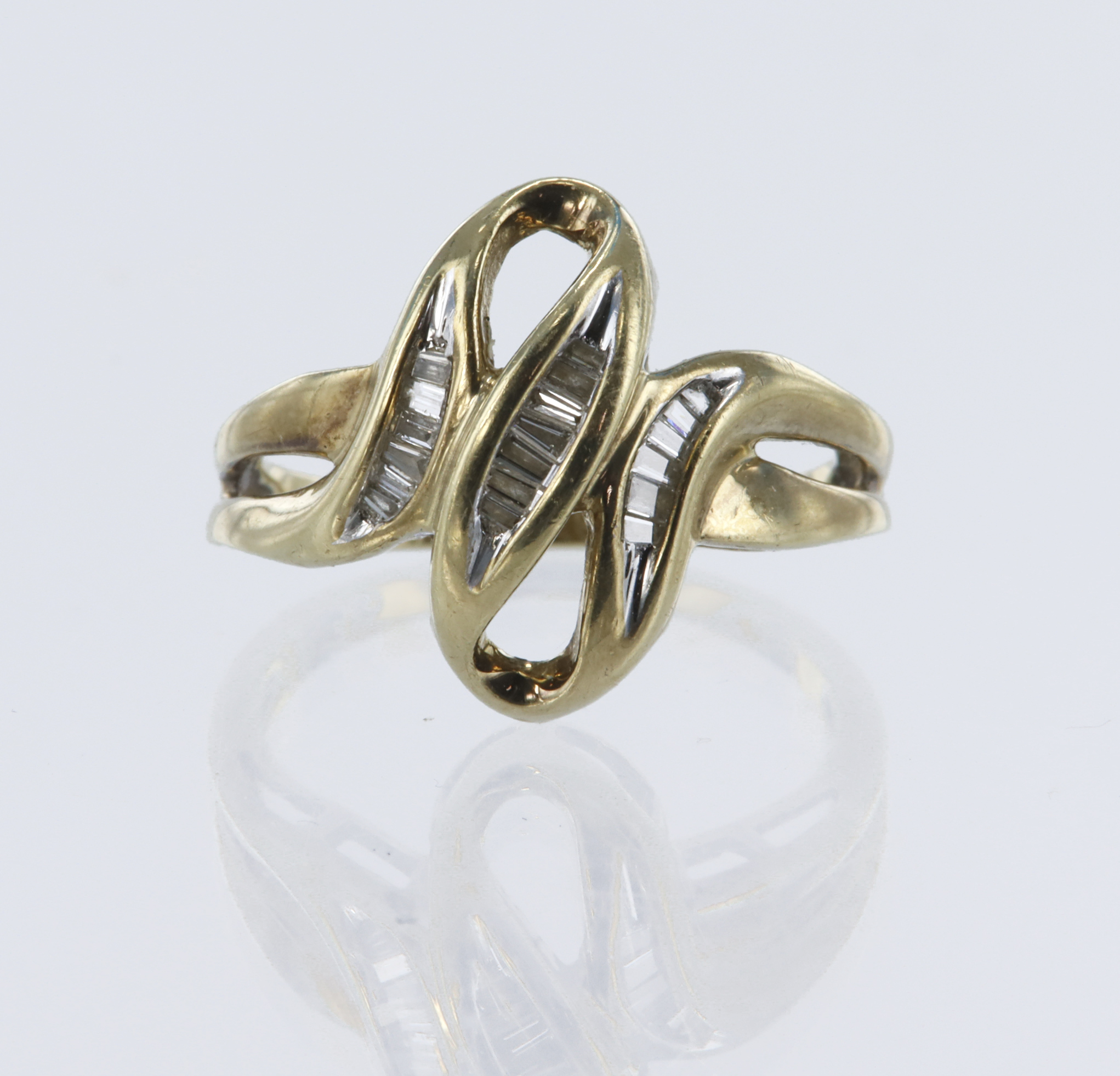 Yellow gold (tests 9ct) diamond set abstract dress ring, nineteen baguette and tapered cut diamonds,