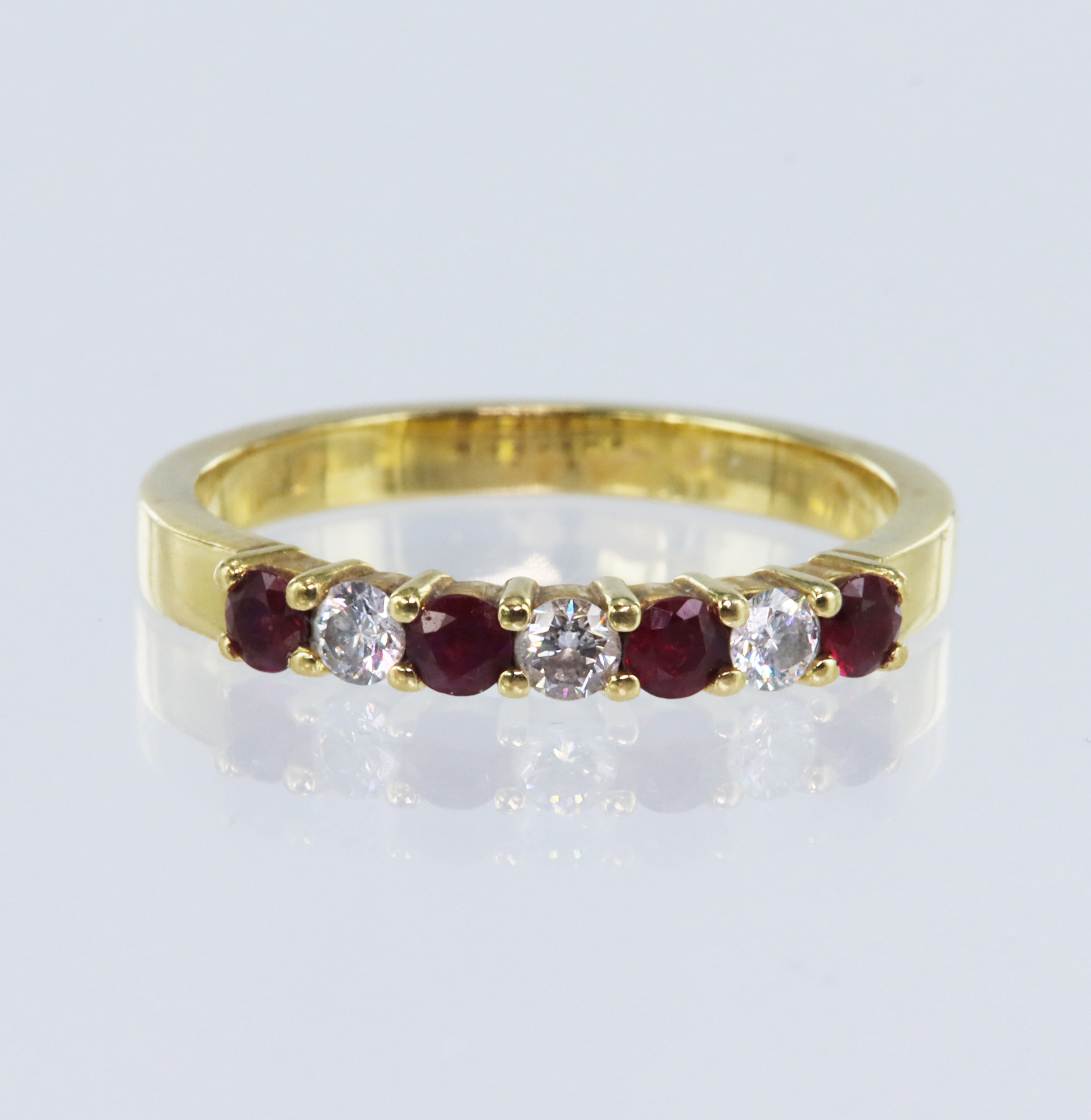 18ct yellow gold diamond and ruby seven stone eternity ring, set with three round brilliant cut