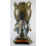 Large glazed majolica three handle vase, supported by three geese, circa 19th Century, marks to
