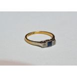 A 18ct gold ring millegrain set a sapphire and two diamonds, size L.