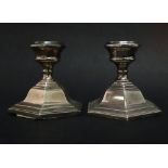A pair of filled silver candlesticks of squat form with stepped bases, Birmingham 1959, height 8cm.