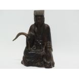 A Chinese bronze figure of a seated deity holding a fly whisk, height 17cm.