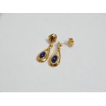 A pair of high purity gold drop earrings set with sapphire cabochons.