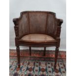 A late 19th century French Bergere armchair with laurel leaf carved and turned frame on turned and