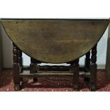 An 18th century and later English oak drop leaf table of oval form, fitted a single drawer and