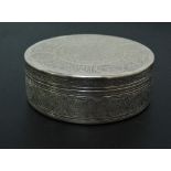 An Egyptian circular silver box and cover the lid decorated with a border of calligraphy within