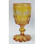 A good 19th century amber glass Bohemian goblet, the sides engraved with five cartouches of