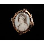 A good early 19th century yellow metal mounted oval portrait miniature of a young girl on ivory, the