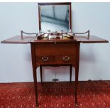 An Edwardian mahogany metamorphic dressing table, the rising interior fitted with numerous silver