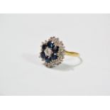 An 18ct yellow and white gold cluster ring set a central diamond of 0.15ct spread approximately,