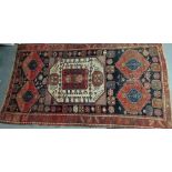 An early 20th century Kazak rug, South West Caucasus, the central rectangular figured lozenge with