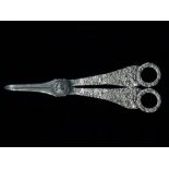 A good pair of silver grape scissors, the handles finely cast with Rococo designs London 1819, maker