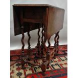 A Queen Anne style walnut drop leaf gateleg table of small proportions, fitted two drawers above a