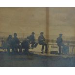 An early sepia print photograph of fishermen resting on the cliff above Newlyn Harbour, framed and