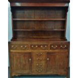 A good George III period oak dresser, the open five plank back fitted two shelves below a moulded