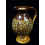 A late 19th century Doulton Lambeth stoneware ewer decorated with a band of flowers and foliage,