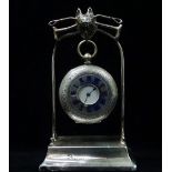 A late 19th/early 20th century half hunter silver cased pocket watch on a filled silver stand