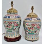 A near pair of Chinese porcelain famille rose lamp bases with brass and wood fittings, decorated