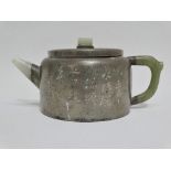 A late 19th or early 20th century Chinese pewter cased Yixing teapot with engraved calligraphy and a