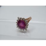 Ruby and diamond ring - A .750 yellow gold ring set a large oval cut faceted ruby, length 41mm,