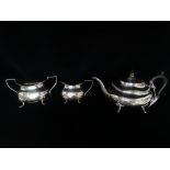A silver three piece tea service of four footed design with gadrooning to edge of teapot, comprising