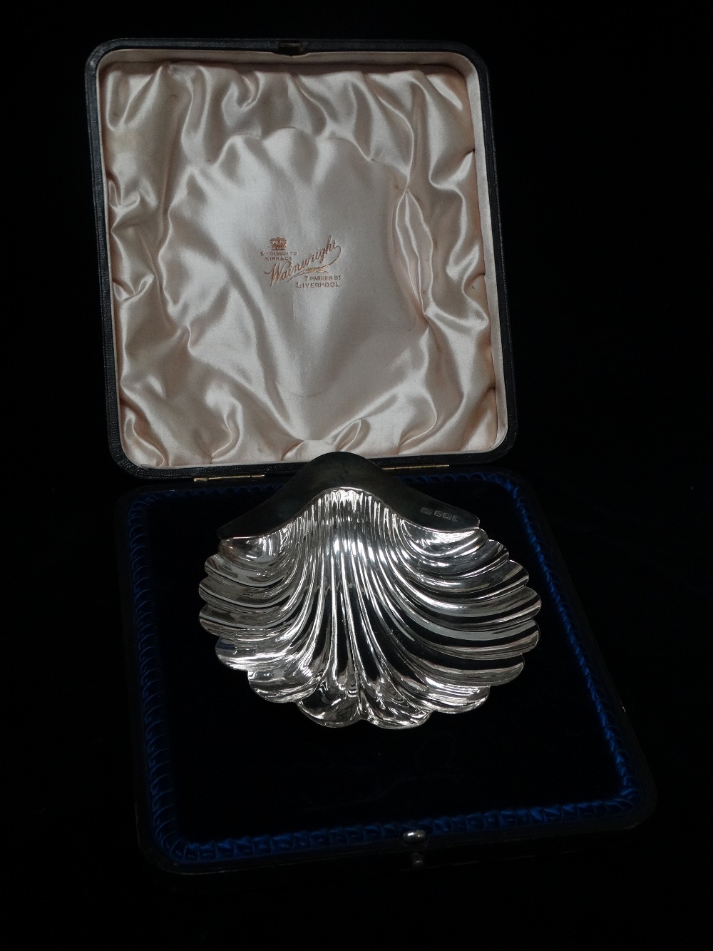 A silver scallop shaped dish raised on three bun feet, Sheffield 1901, maker's mark for Atkin