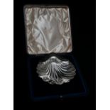 A silver scallop shaped dish raised on three bun feet, Sheffield 1901, maker's mark for Atkin