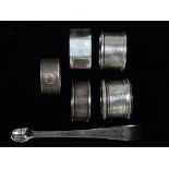 Five silver napkin rings, together with a pair of Georgian bright cut acorn sugar nips, weight