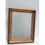 A 19th century gilt framed wall mirror - A gold leaf frame with egg and dart detail, having a mirror