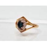 18ct gold diamond and sapphire ring - An 18ct gold ring set an oval sapphire surrounded by eight