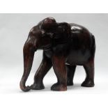 A large carved wood elephant circa 1810 - A stained wood large elephant with bone eyes, bears