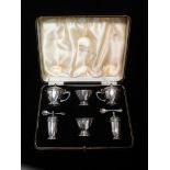 A cased silver cruet set with blue glass liners, comprising six pieces, Birmingham 1938, maker's