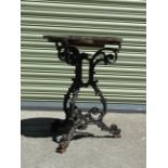 A cast iron garden table with a circular wooden top, circa 1900, height 71cm, diameter 53cm.