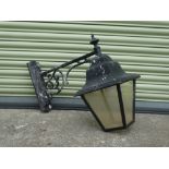 A black painted aluminium wall mounted lantern with four glazed panels, height 63cm, width 31cm,