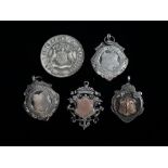 Four hallmarked silver pendant medals and another, two with applied yellow metal shields, all