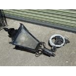 A black painted wrought iron wall mounted street lamp with four glazed panels, height 110cm, depth