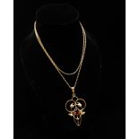 Art Nouveau - A 9ct gold chain and Art Nouveau pendant with inset red stone to centre, height 4cm.