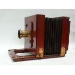 A half-plate mahogany field camera with brass-bound lens with Waterhouse stops, square-cornered