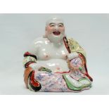 Chinese 20th century ceramic Buddha - A polychrome decorated Buddha sat holding a bead and jade