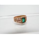 Emerald ring - An 18ct gold ring set an emerald cut emerald and a two line row of diamond chips to